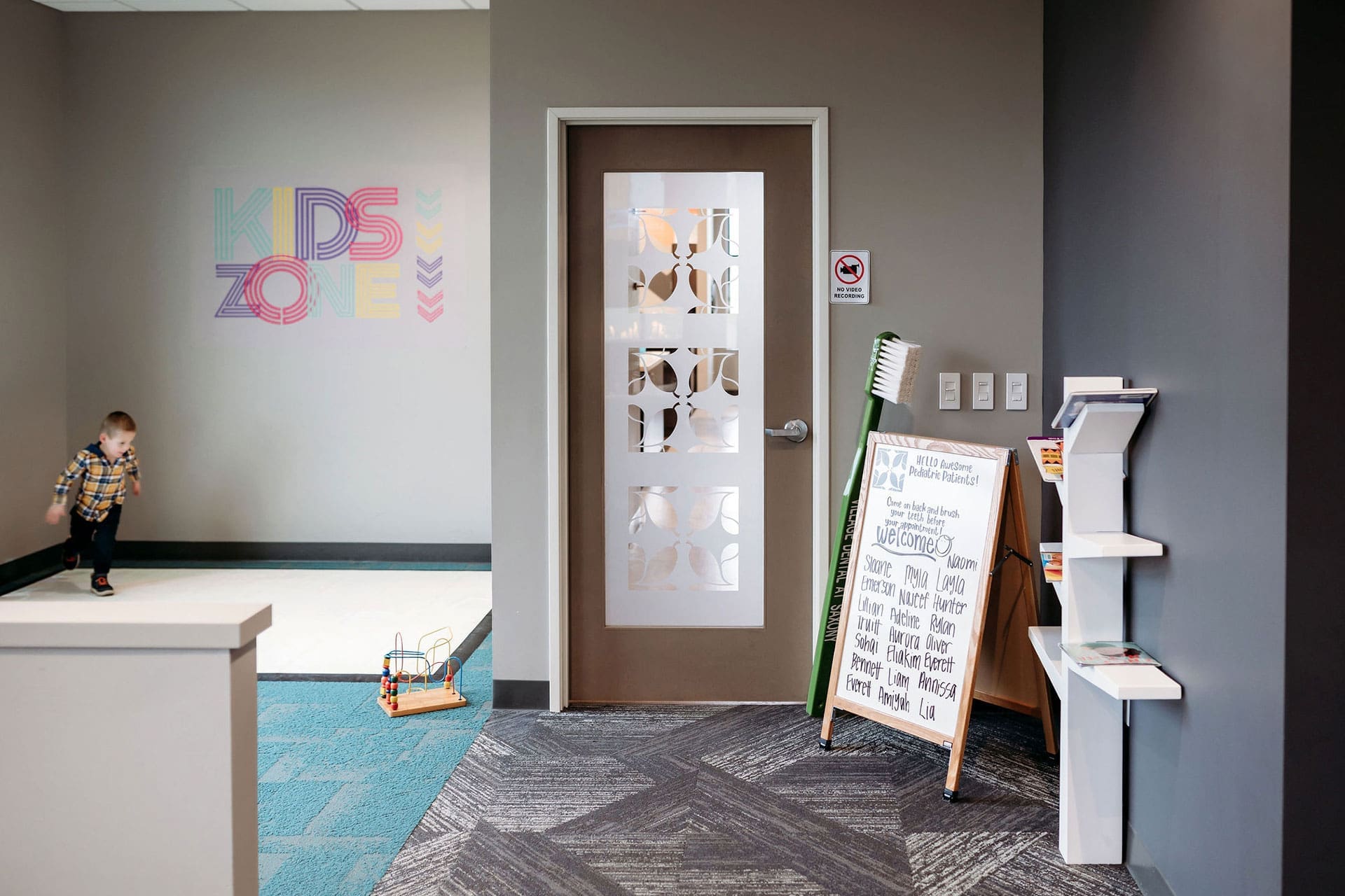 Kids Zone play area at Village Dental at Saxony featuring a colorful welcome board and toys in Fishers, IN