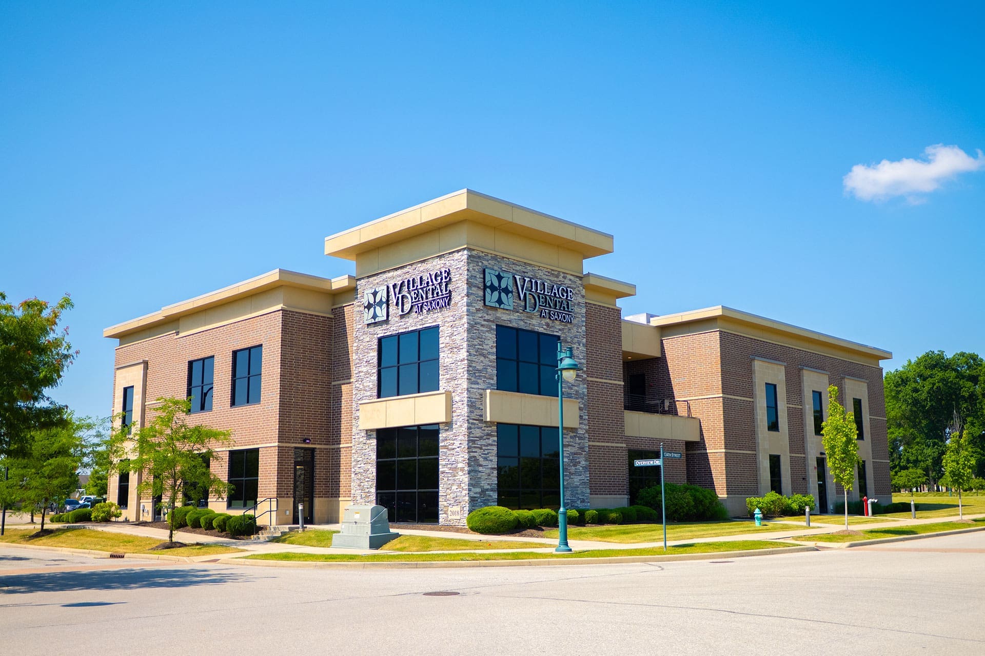 Village Dental at Saxony clinic building exterior on a bright sunny day with blue sky in Fishers, IN